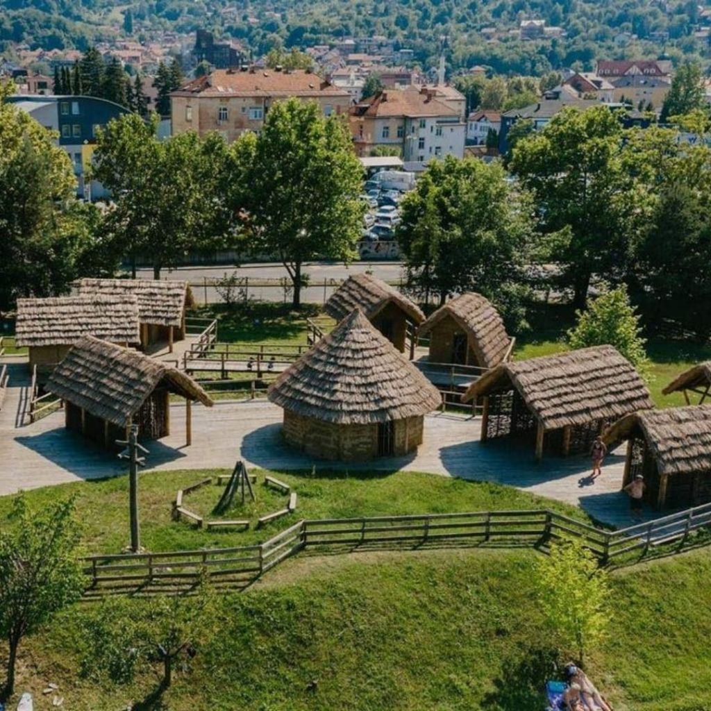 Reconstructed Neolithic pile dwellings with thatched roofs in a green park