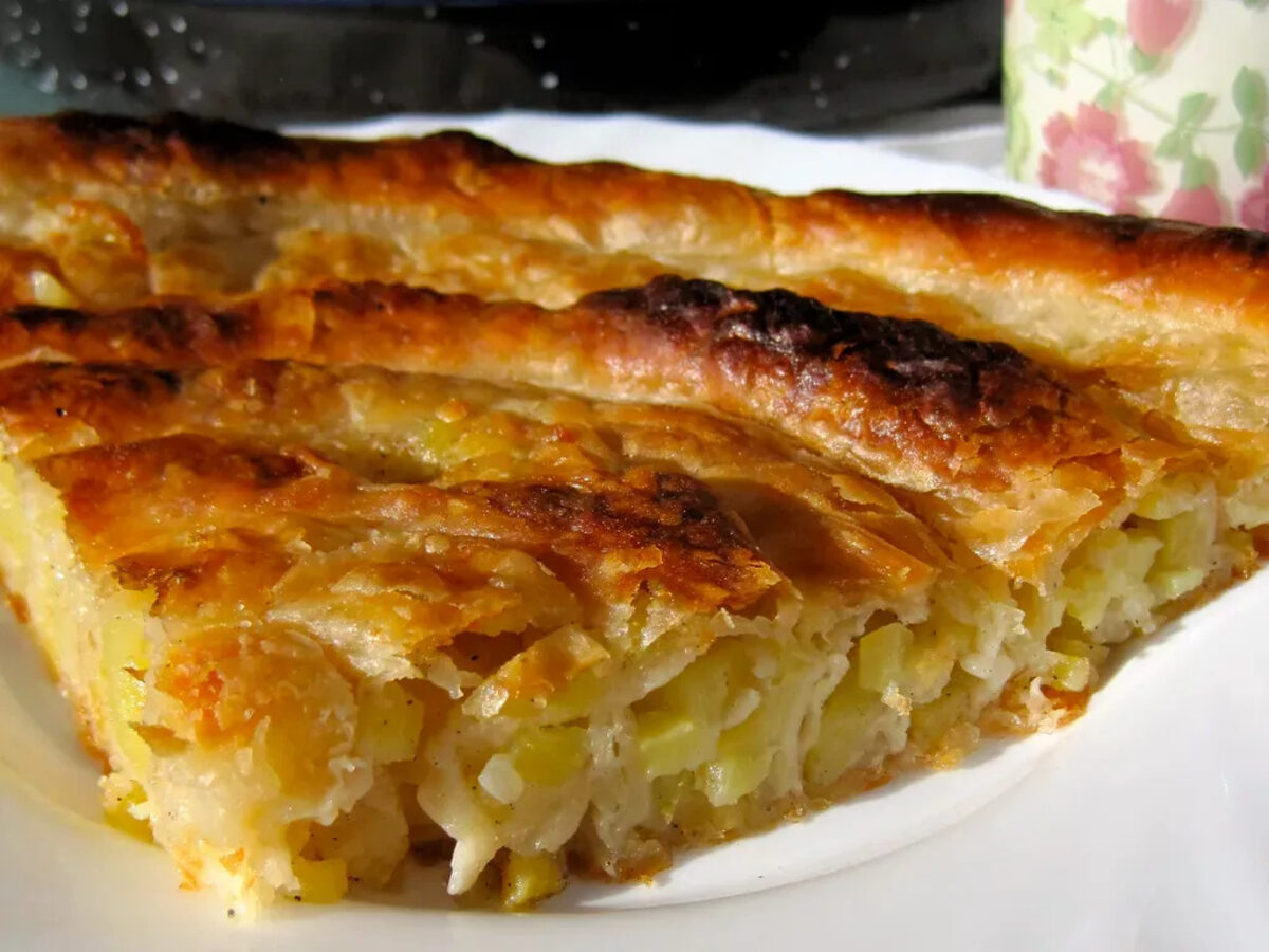 A close slice of flaky pita with a soft potato filling