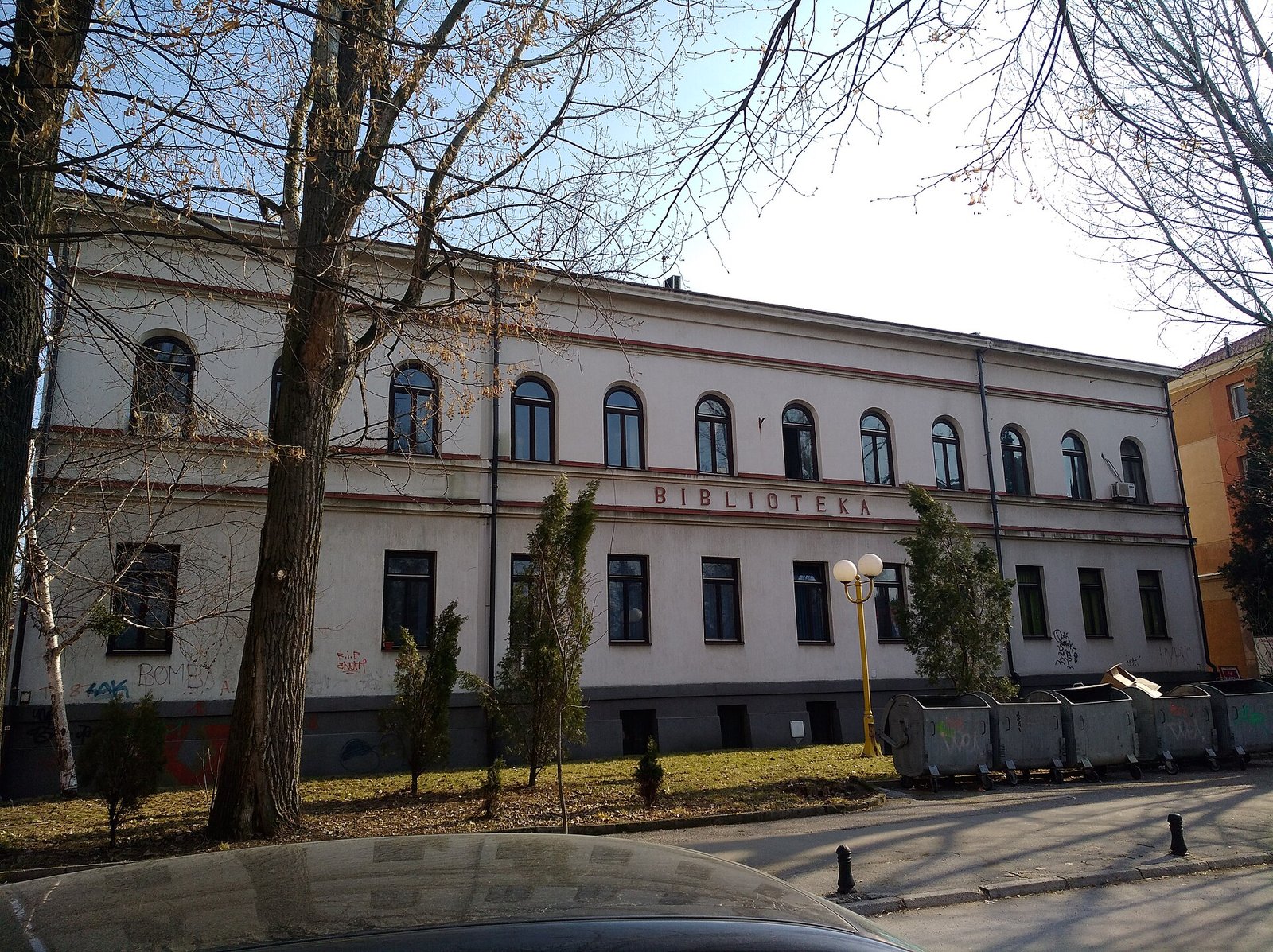The long two-storey library building with tall windows, behind bare trees