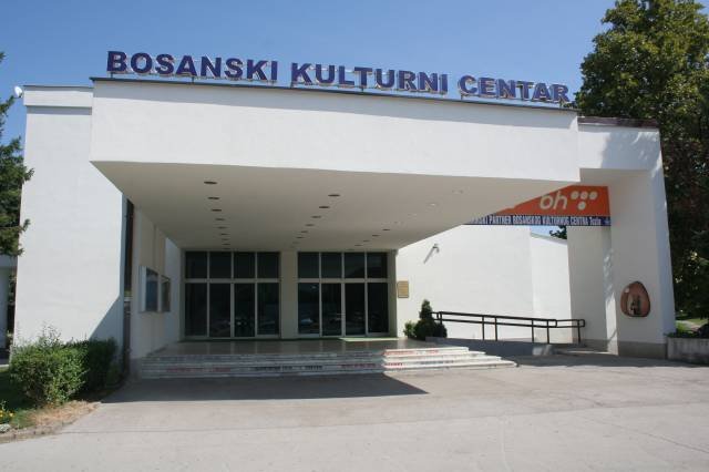 The white front and entrance canopy of the Bosanski kulturni centar in sunshine, with no people