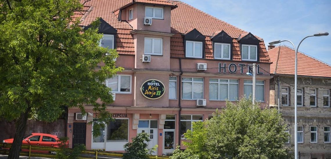 The front of Hotel Miris Dunja 88, a pink and brown house with a red roof