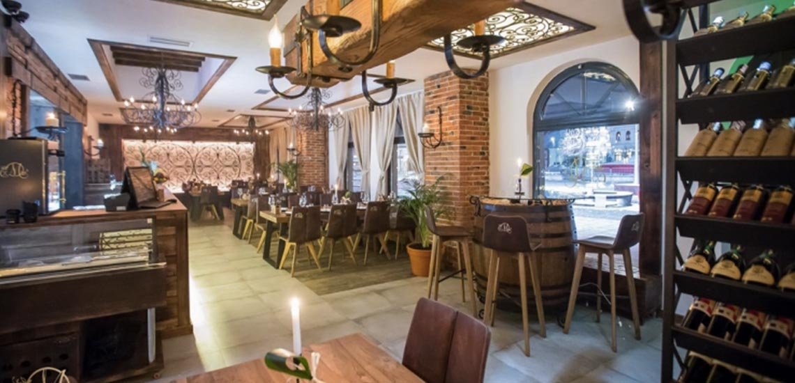 The restaurant's interior: candle-lit tables, wine racks, a bar and arched windows