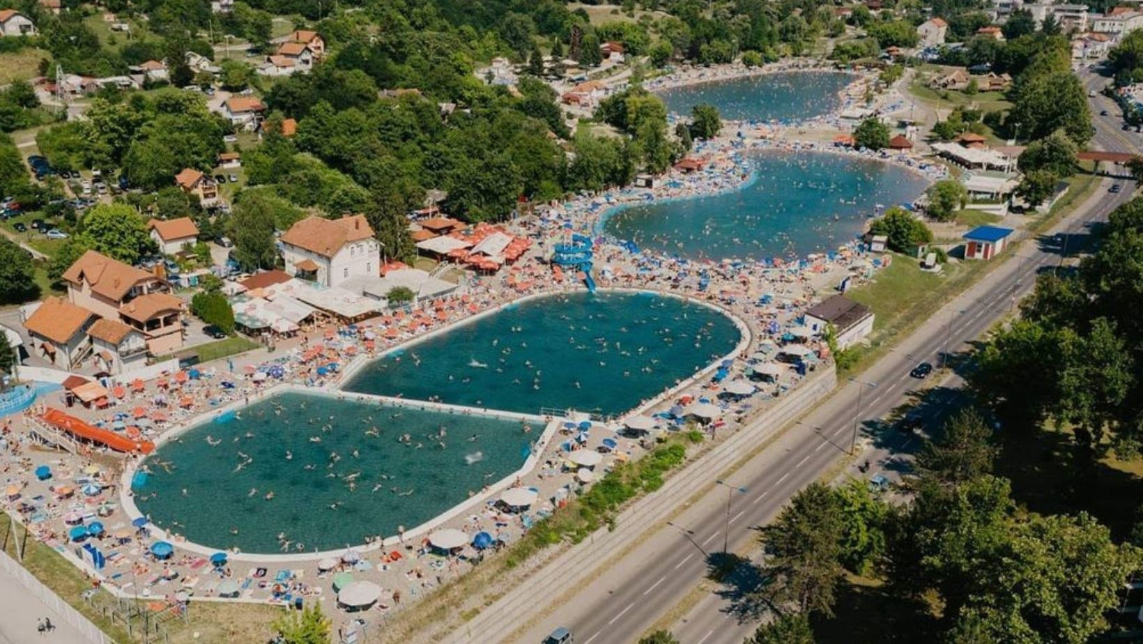 The Pannonian salt lakes from the air on a summer day, crowded with swimmers and umbrellas